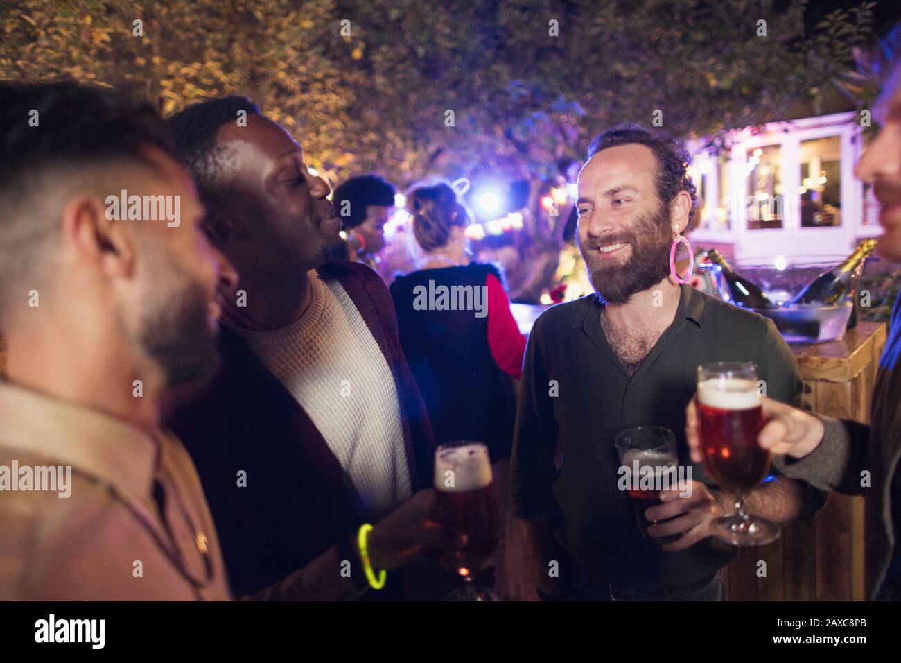 Amici maschi felici che bevono birra alla festa in giardino Foto Stock