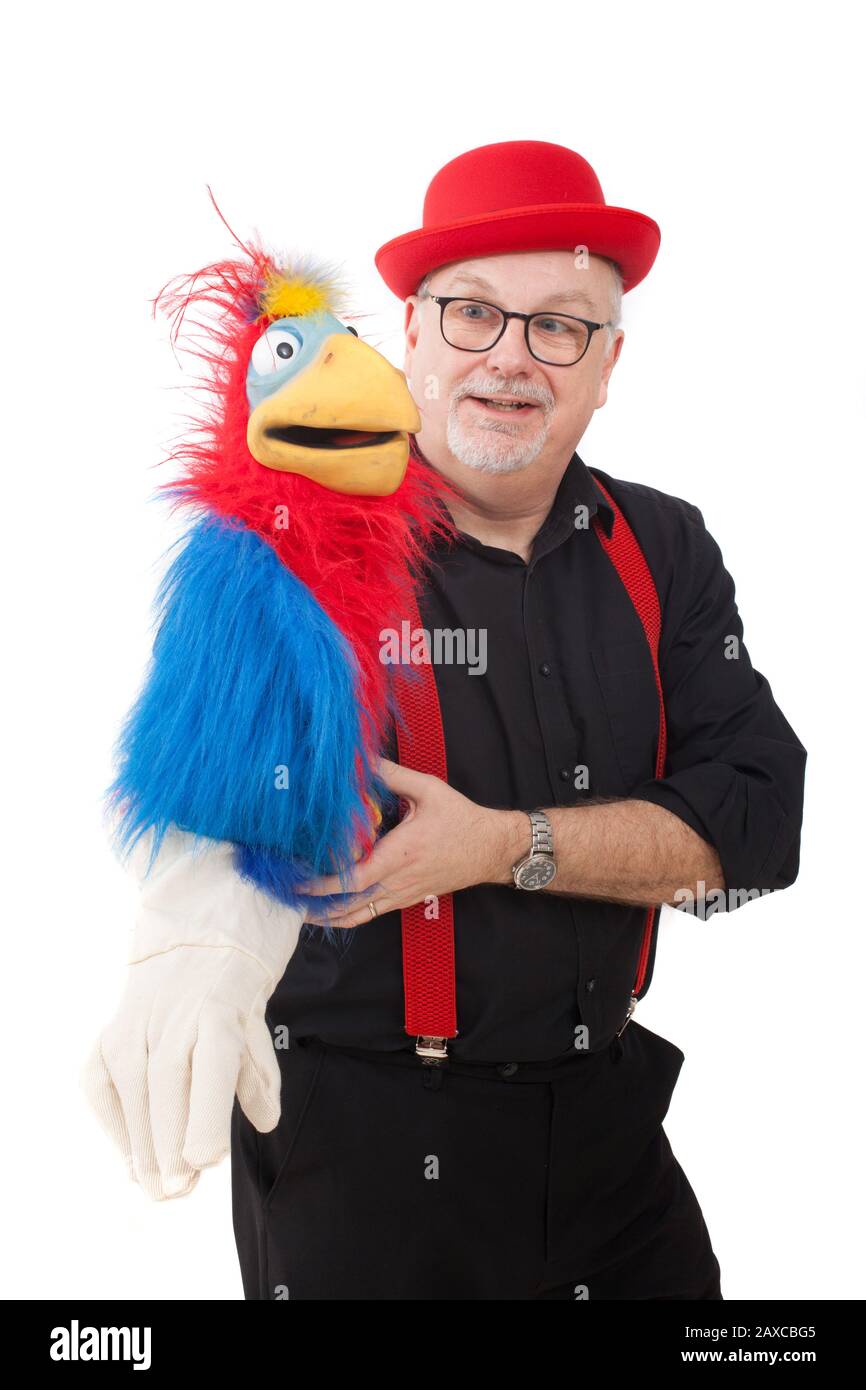 Un ventriloquista con un pappagallo sul suo braccio Foto Stock