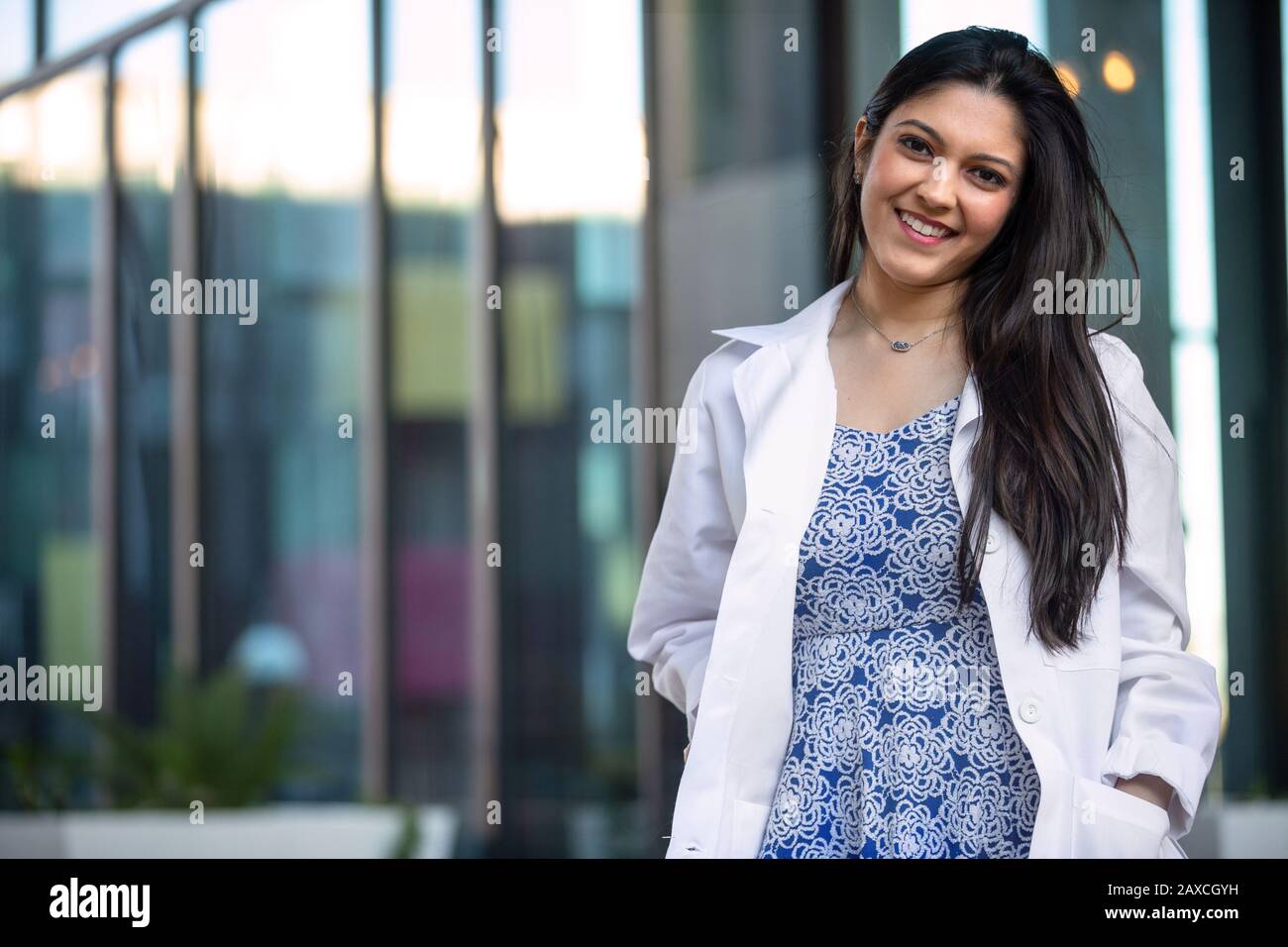 Giovane professionista medico al suo nuovo lavoro di carriera, ritratto in piedi in un cappotto bianco Foto Stock