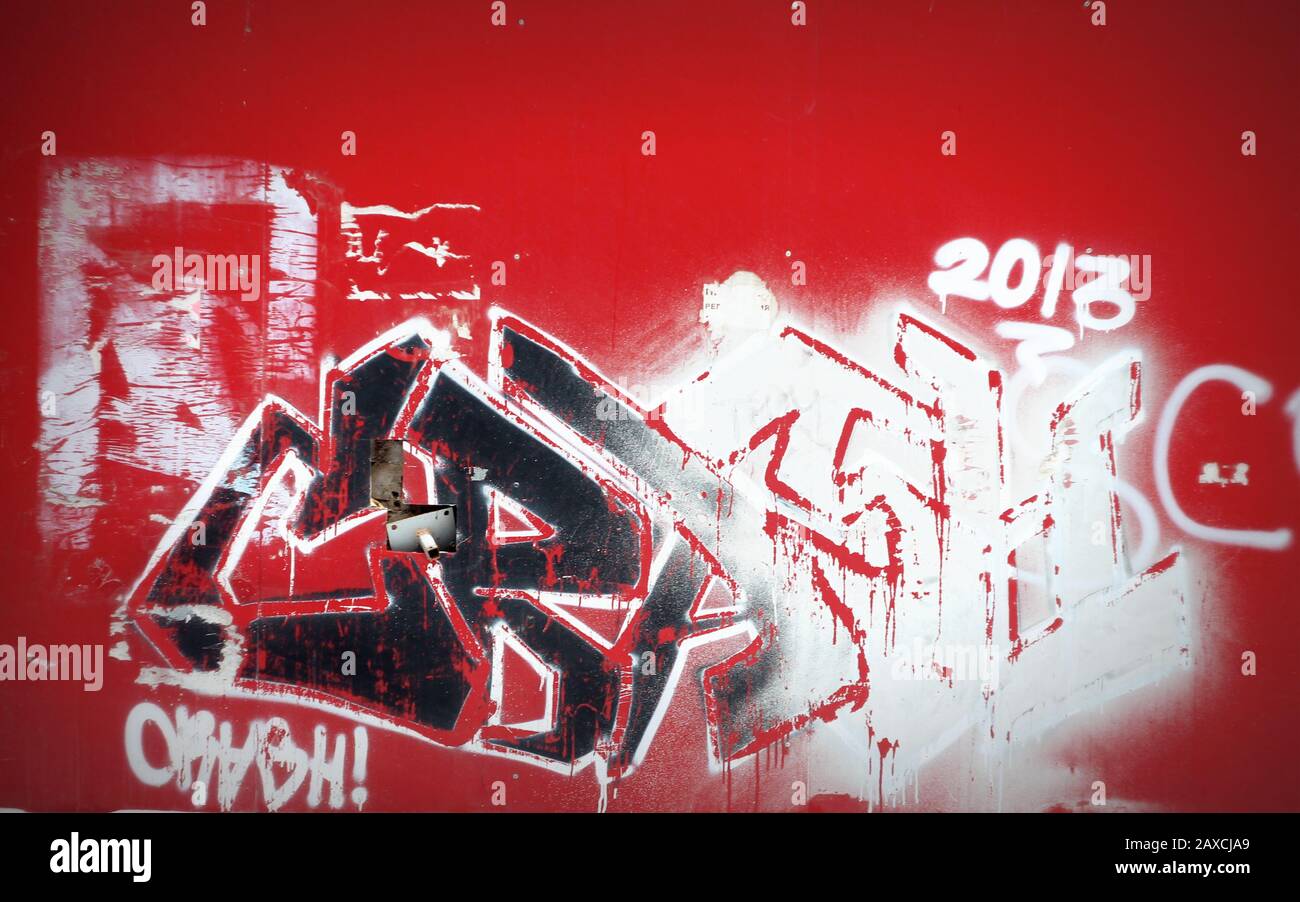 Muro rosso con graffiti colore bianco e nero, Street art pittura a parete con vernici spray. Foto di scorta per Web, stampa, sfondo e sfondo Foto Stock