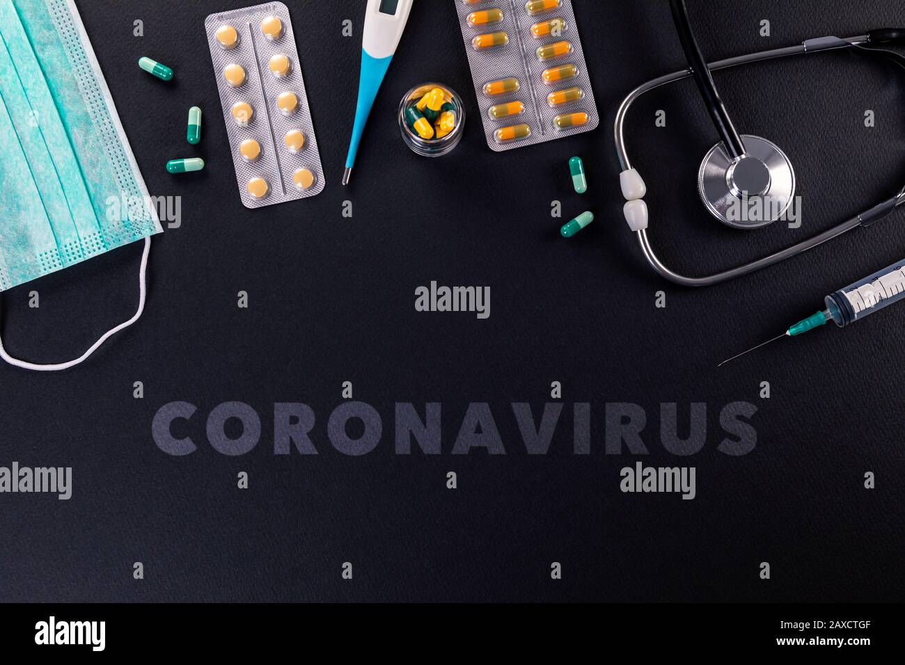 Maschere protettive, medicinali, termometro, stetoscopio e siringa con testo di coronavirus su sfondo nero. Romanzo coronavirus 2019-nCoV, MERS-Cov m Foto Stock