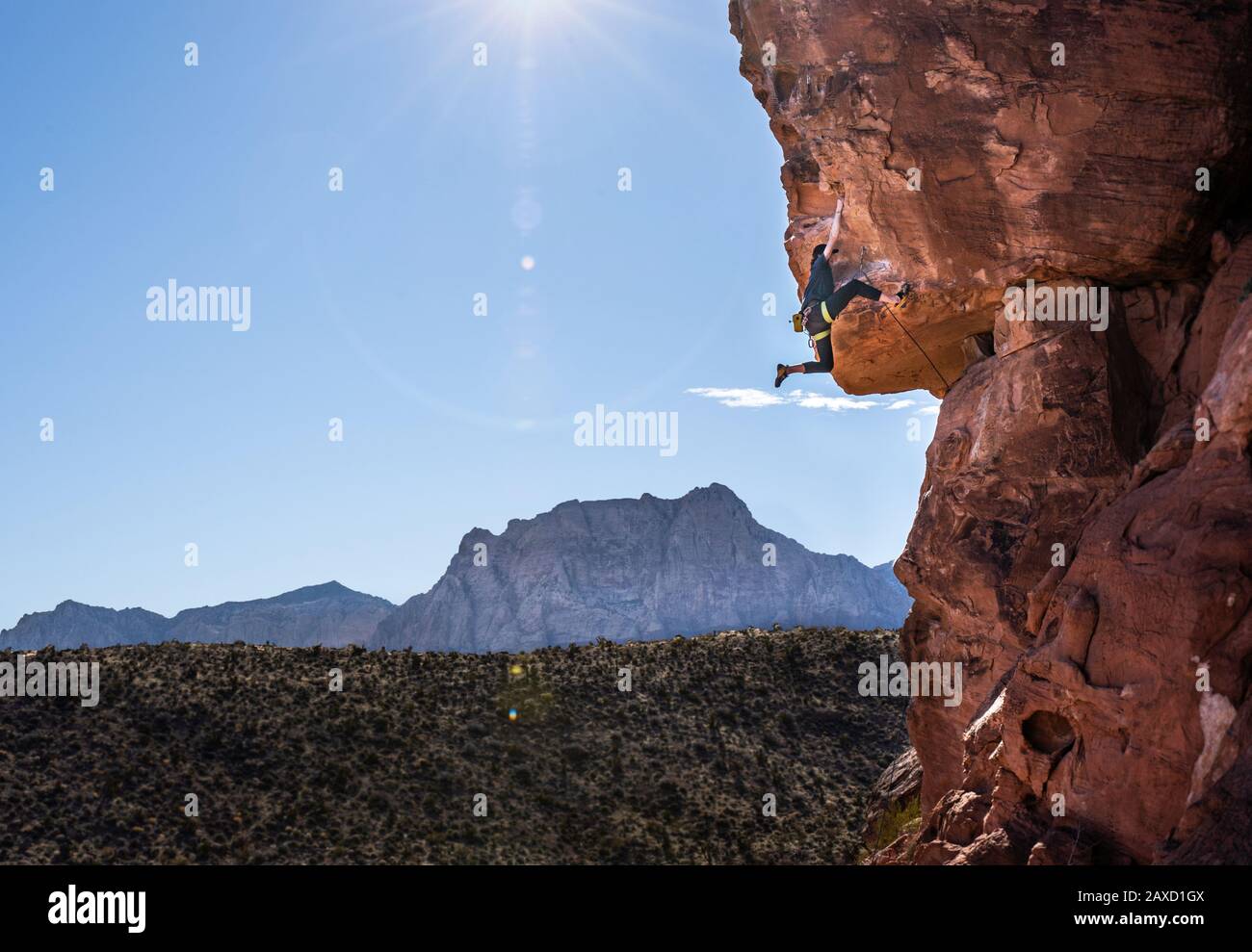 Uomo scalatore di roccia su scogliera colpo d'azione con cielo blu Foto Stock