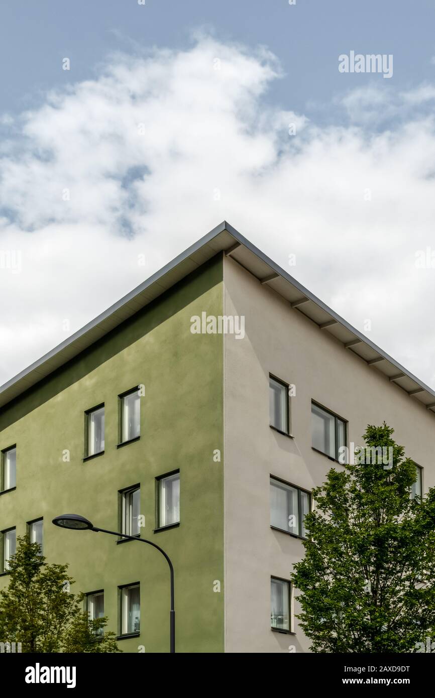 Angolo di un verde edificio residenziale circondato da alberi. Moderna città verde. Foto Stock