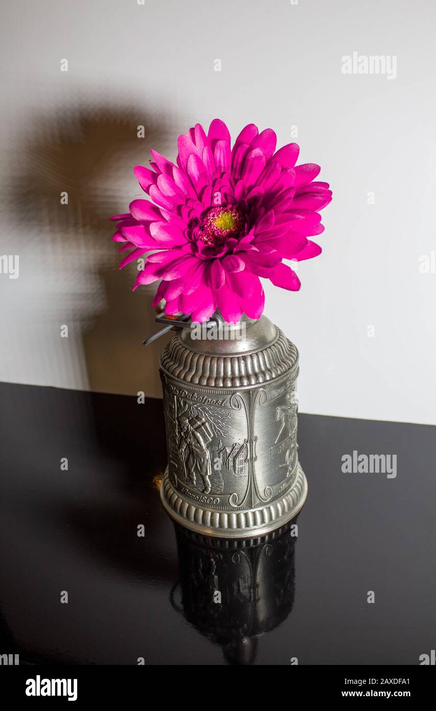 vecchia tazza di stagno con un fiore di tessuto all'interno Foto Stock