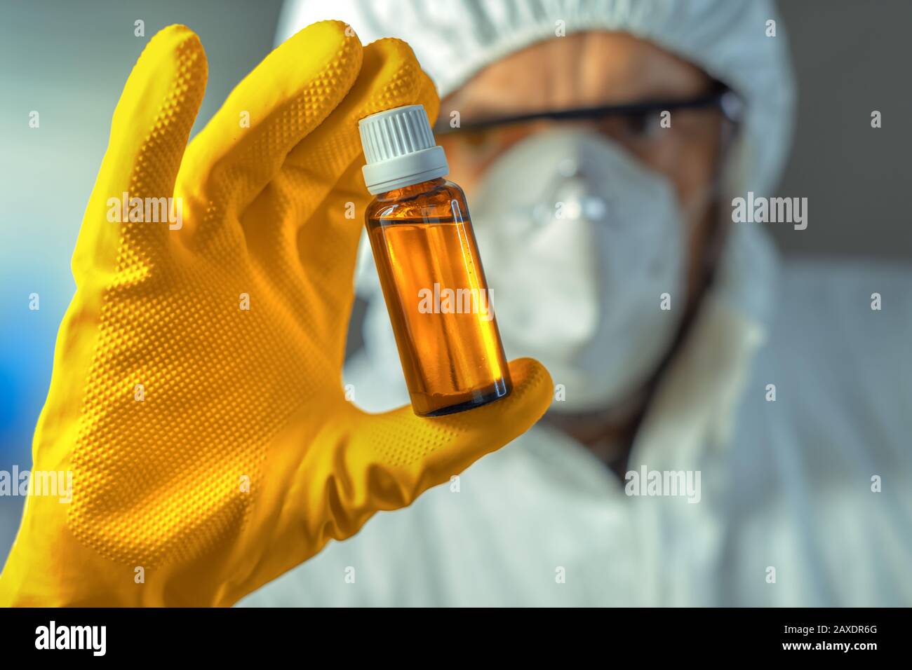 Operatore medico che tiene una bottiglia di sciroppo di vetro, da vicino con fuoco selettivo Foto Stock