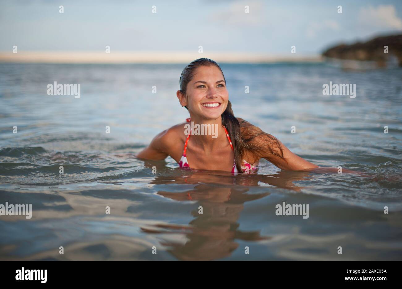 Felice giovane donna nuotare in mare su una spiaggia. Foto Stock