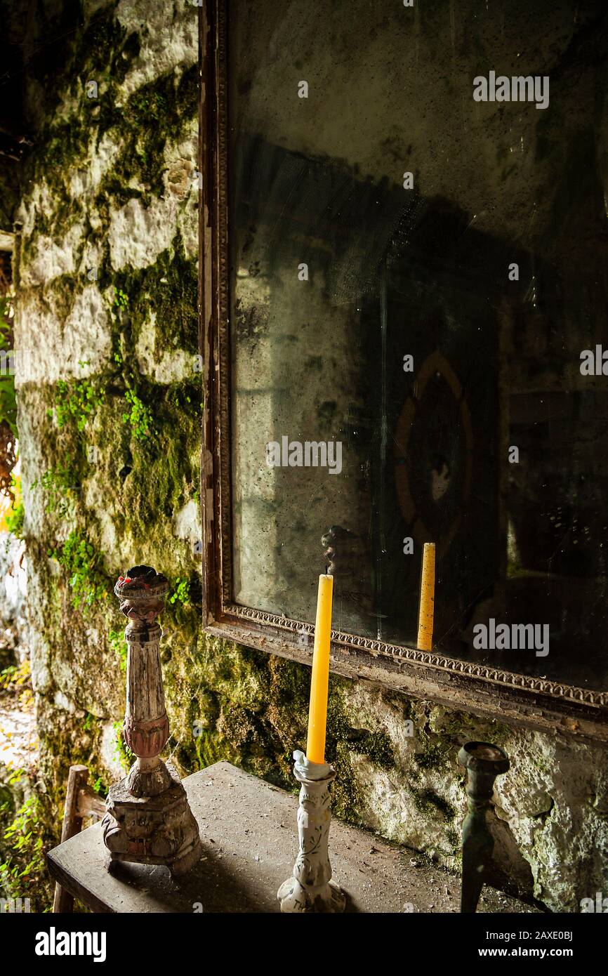 Supporti per candele e specchio nella stanza mossy murata Foto Stock