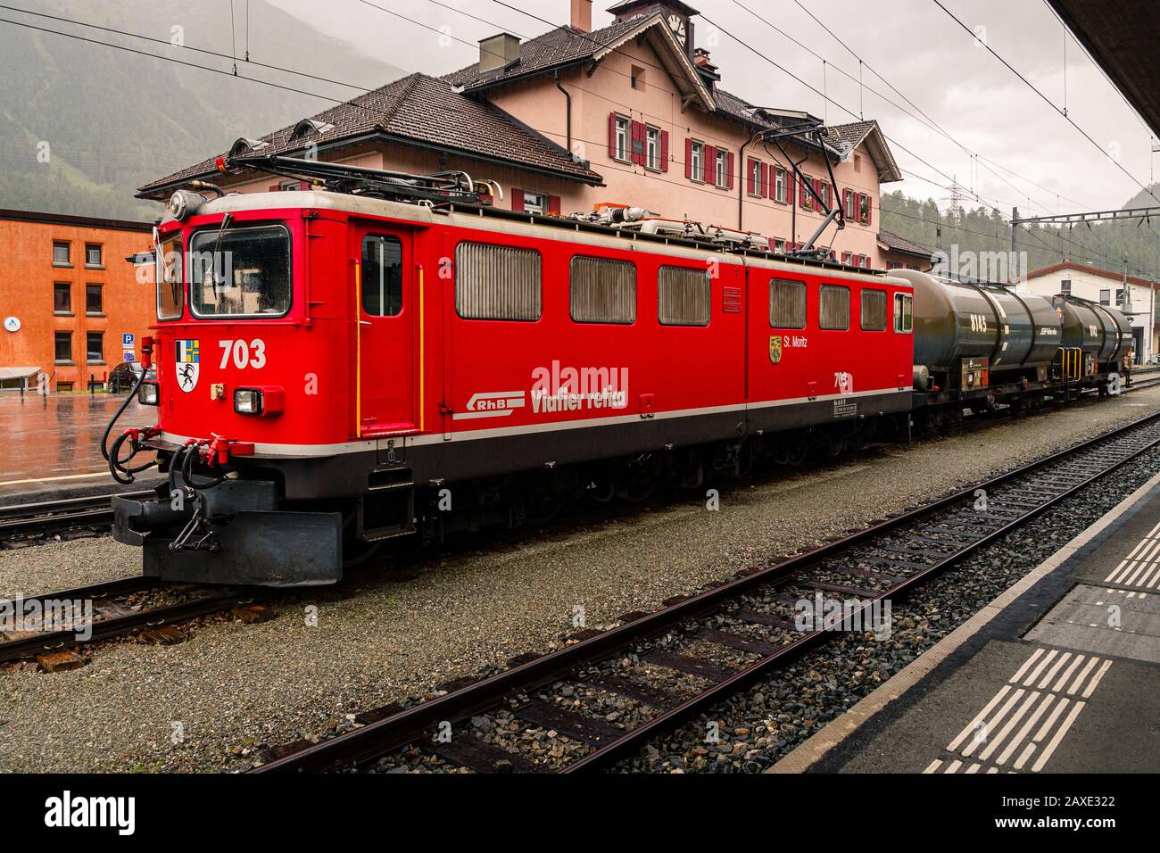 Pontresina, Grigioni, Svizzera - 9 agosto 2016 : locomotiva elettrica rossa della Ferrovia Retica di fronte al treno merci nella Pontresina rai Foto Stock