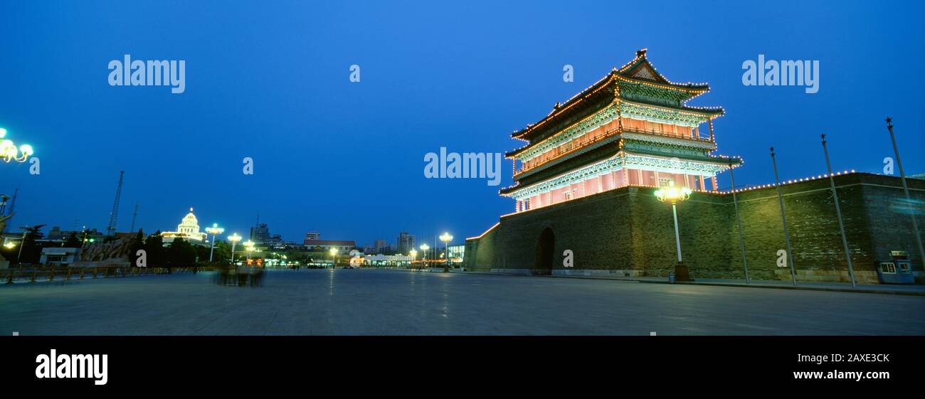 Edificio lungo la strada illuminata di notte, porta Zhengyang, Piazza Tiananmen, Pechino, Cina Foto Stock