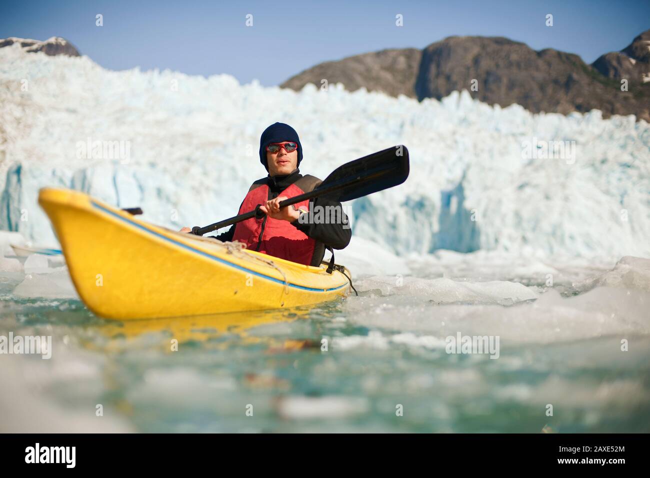 Uomo kayak attraverso acqua ghiacciata Foto Stock