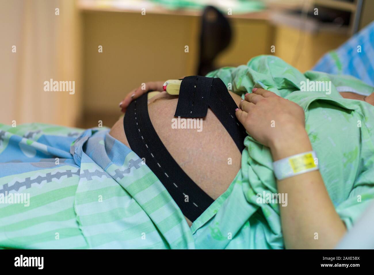 Donna incinta in ospedale con campana cardiotocografica Foto Stock