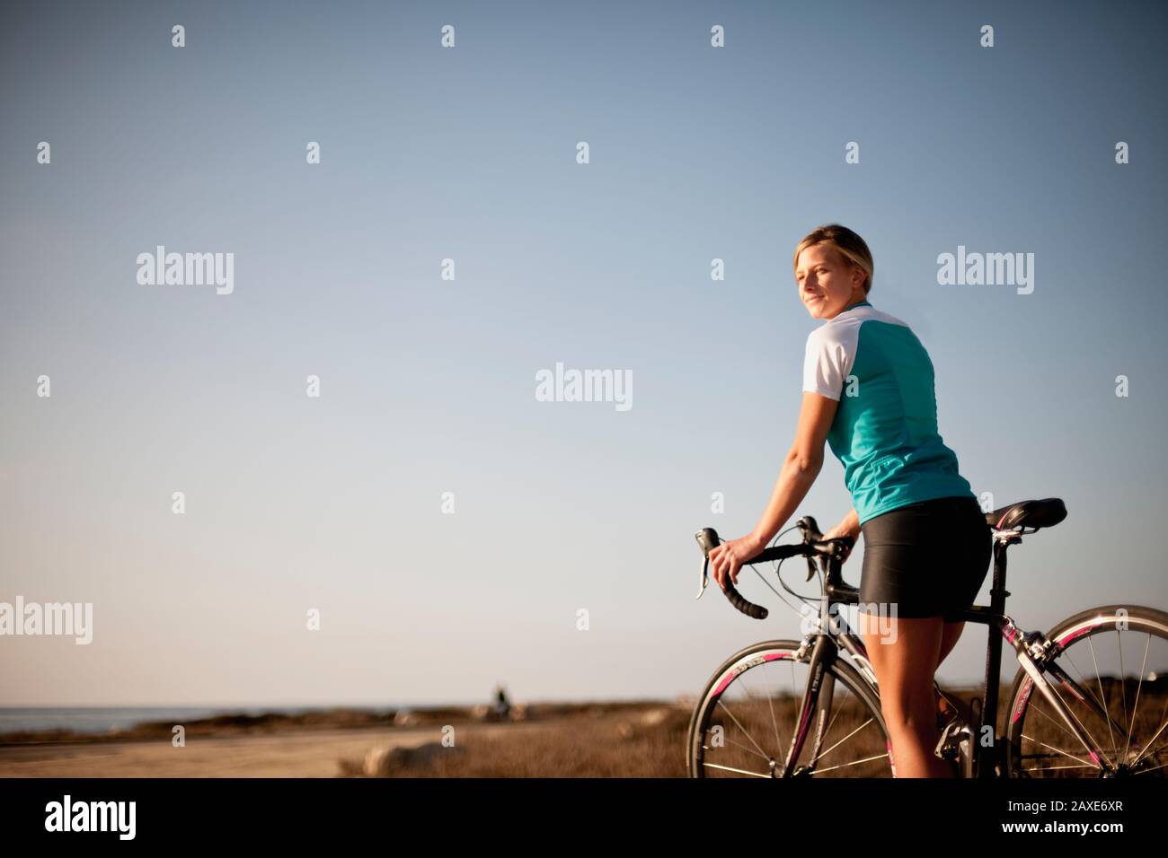 Una giovane donna ciclista treno accanto alla spiaggia. Foto Stock