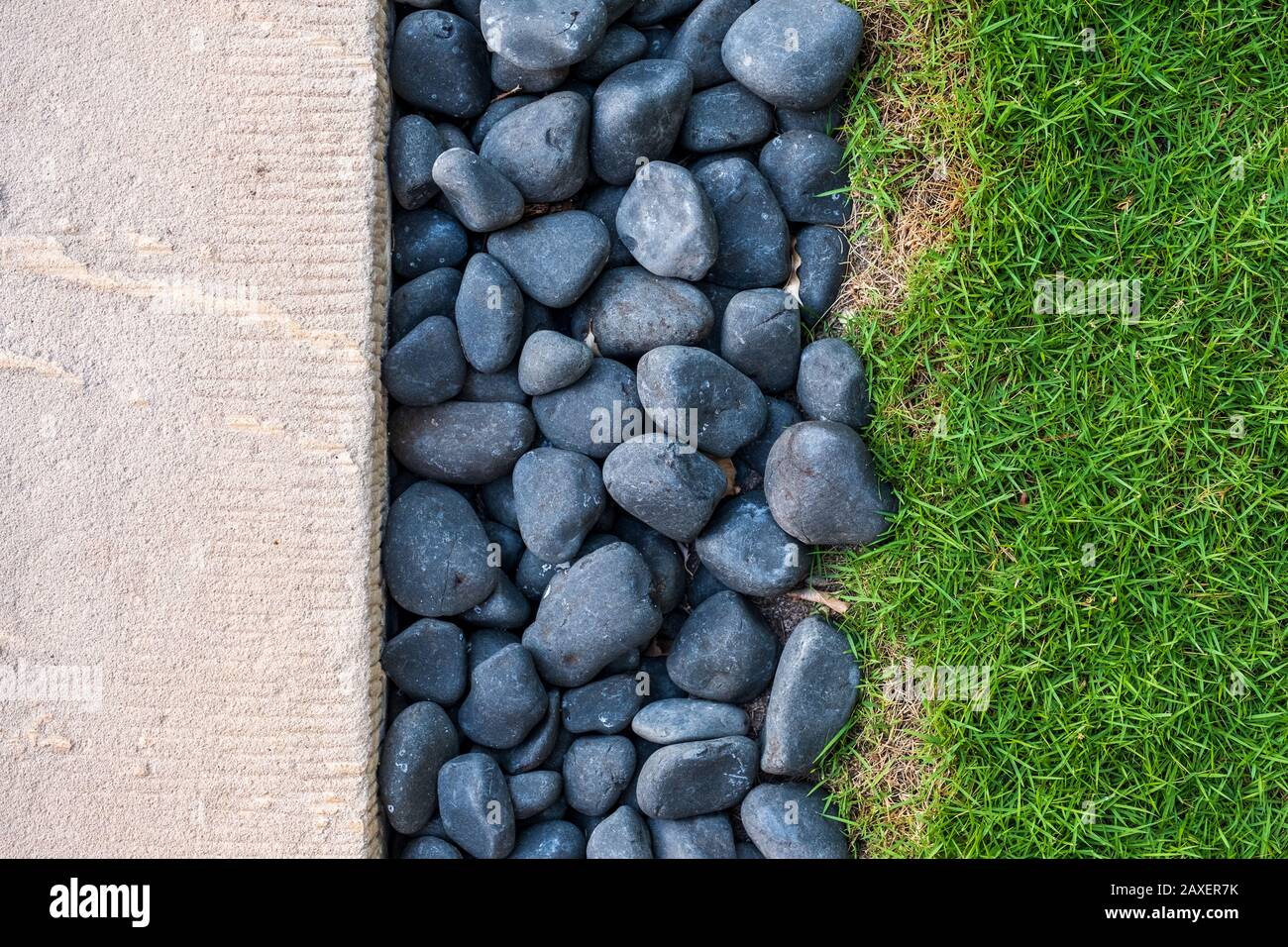 Una foto tricolore di cemento bianco, pietre blu e erba verde con spazio per il testo Foto Stock