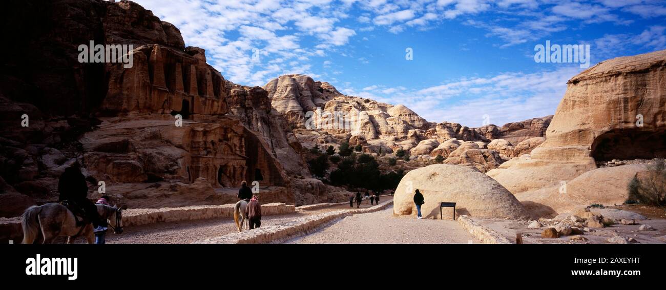 Turisti a piedi attraverso antiche strutture, Giordania Foto Stock