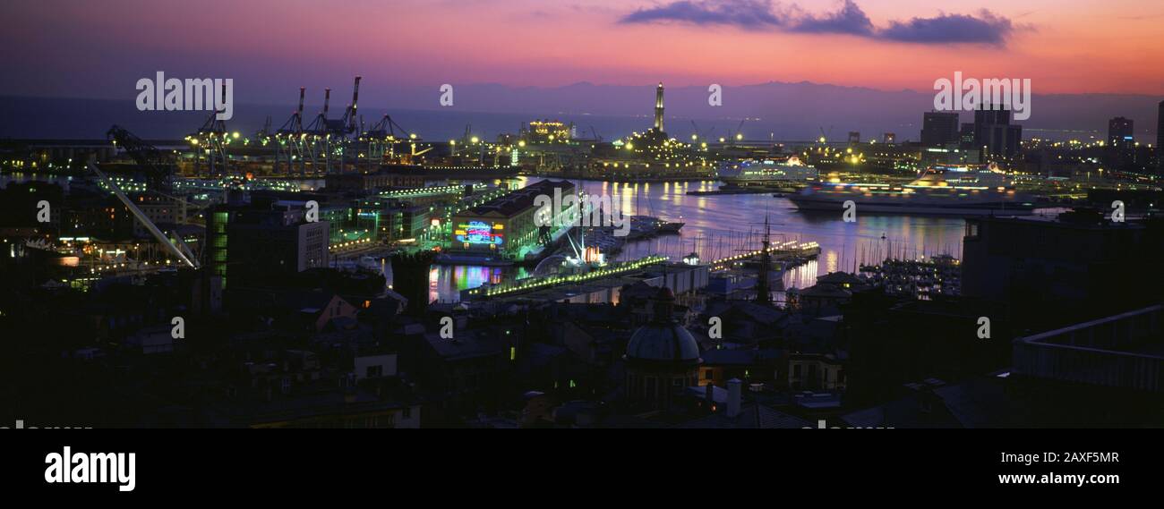 Vista panoramica della città in un porto illuminato al tramonto, Genova, Liguria, Italia Foto Stock