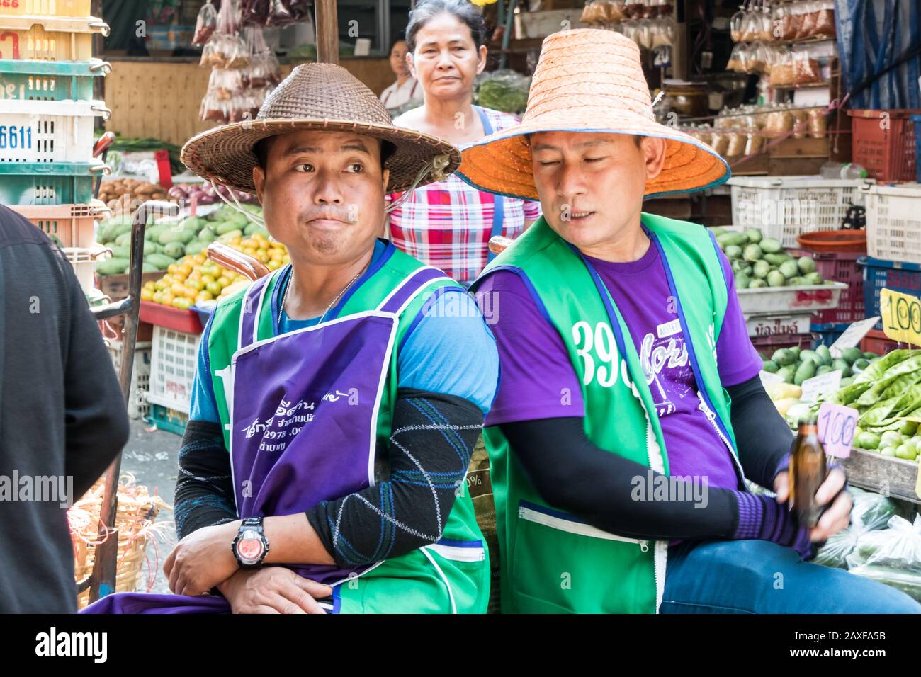 Bangkok, Thailandia - Gennaio 9th 2020: I facchini che hanno una conversazione sul mercato umido Khlong Toei. Questo è il più grande mercato bagnato della città. Foto Stock