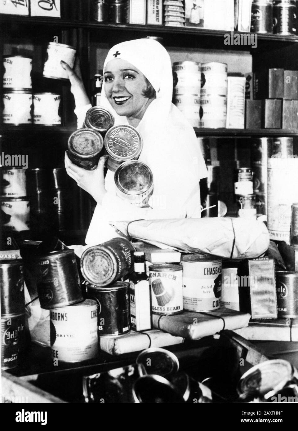 1931 , 10 febbraio , HOLLYWOOD , USA : l'attrice cinematografica BBE DANIELS ( 1901 - 1971 ) , Guida la cooperazione dell'industria cinematografica con LA CROCE ROSSA in campagna per sei carichi di prodotti alimentari per la siccità soffre negli stati occidentali centrali . diverse migliaia di lattine di cibo e 500 dollari in contanti sono stati contrastati da stelle e operai di studio nel corso della fine settimana - CINEMATOGRAFICO - CINEMA - Altro CINEMATOGRAFICO - DIVA - DIVINA - SORRISO - SORRISO - SORRISO - SORRISO - divisa da cromerosina - uniforme - uniforme - MODA - moda - moda - moda - moda - STORIA - FOTO STORICHE - ANNI TRENTA - 30 - '30 - GRANDE DEPRESSIONE AMERICANA - Foto Stock