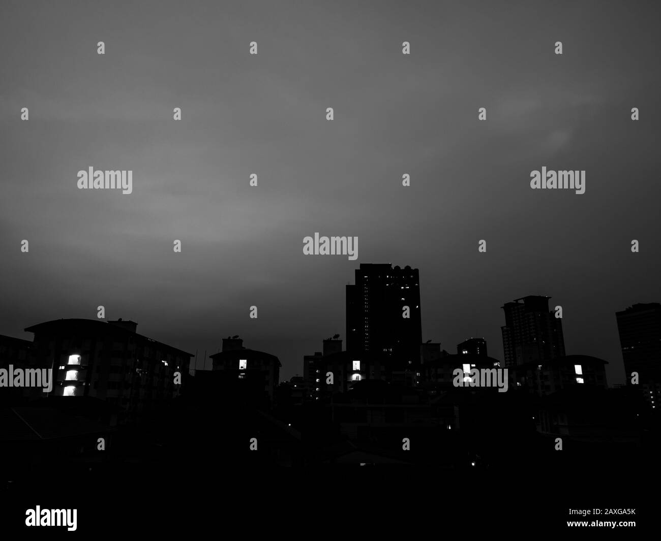 Città oscura, edifici scuri con la luce dalla finestra su sfondo polveroso cielo in stile bianco e nero con spazio copia. Foto Stock