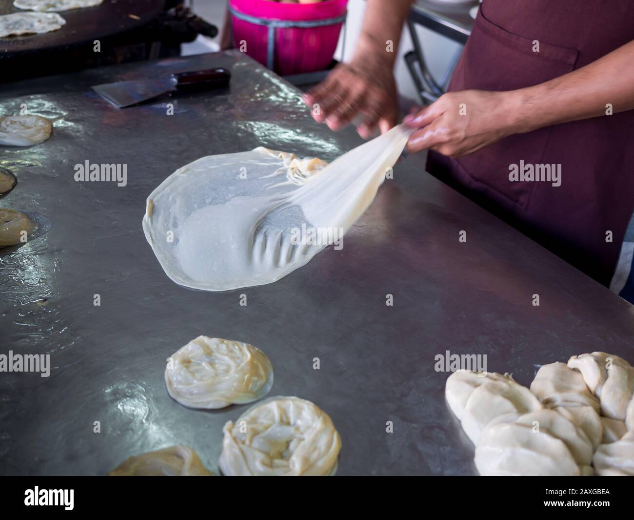 Roti rendendo, roti thresh farina mediante roti maker con olio. Indian tradizionale cibo di strada. Mano rendendo roti. Foto Stock