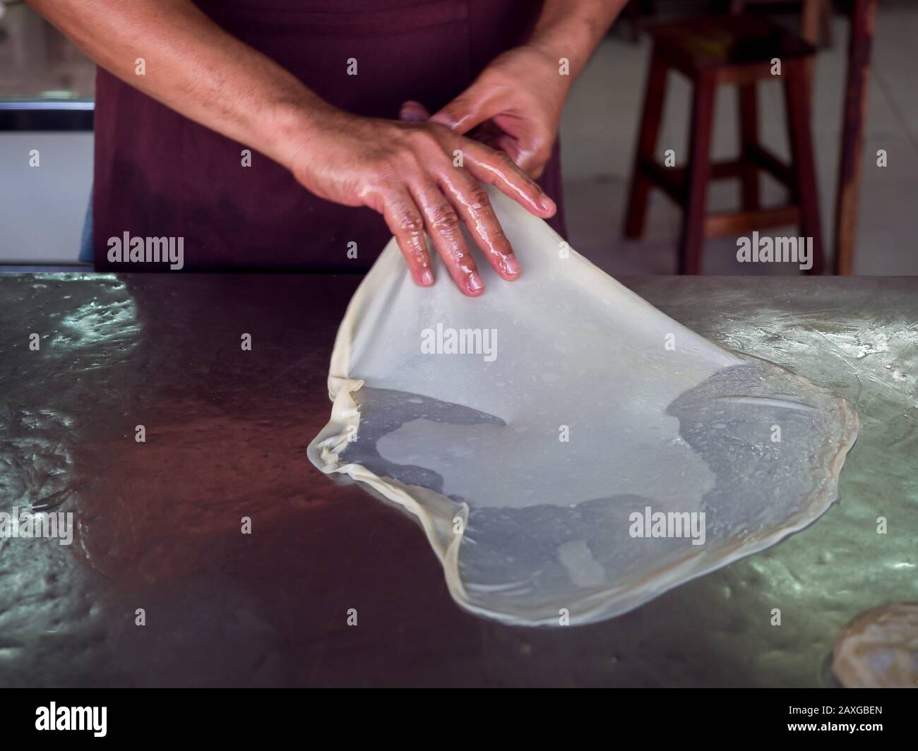 Roti rendendo, roti thresh farina mediante roti maker con olio. Indian tradizionale cibo di strada. Mano rendendo roti. Foto Stock