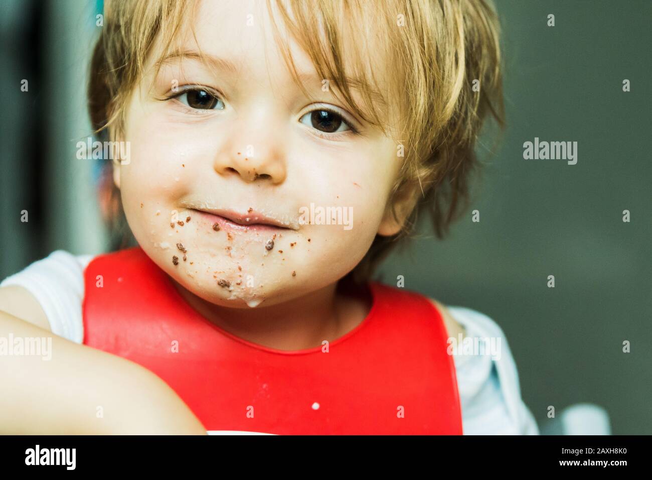 Un bambino adorabile ritratto mangiare torta di spugna di cioccolato Foto Stock