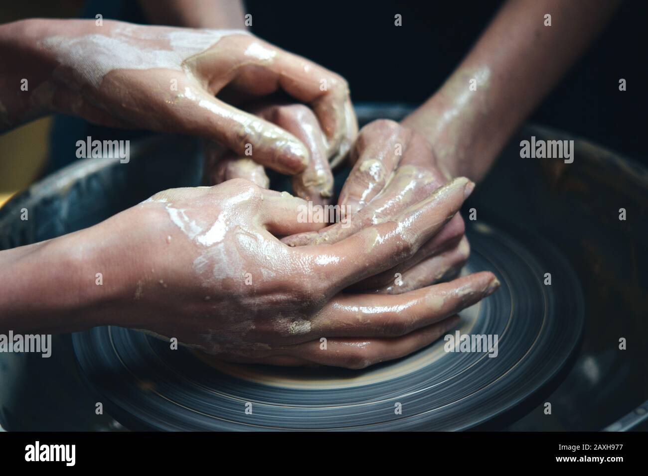 Due persone forgia un vaso di argilla da argilla bianca. Master potter insegnare da argilla in laboratorio primo piano Foto Stock