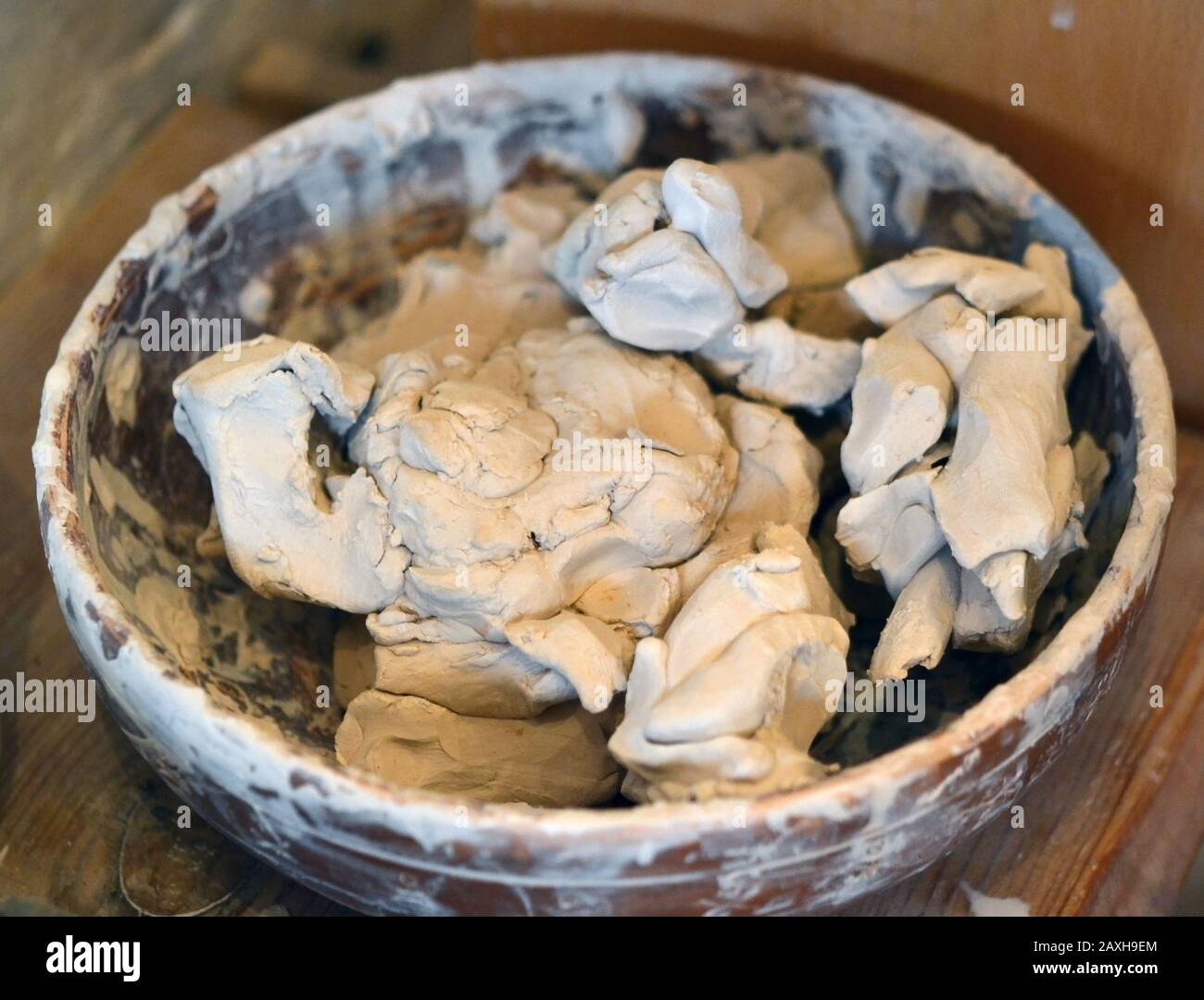 Closeup di creta bianca bagnata. Pezzi astratti di argilla umida in una piastra sul tavolo Foto Stock