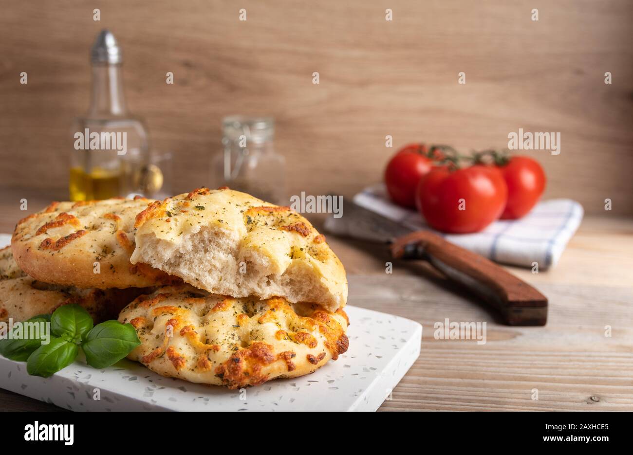 Focaccia italiana cotta in casa con mozzarella ed erbe su un piatto. Foto Stock