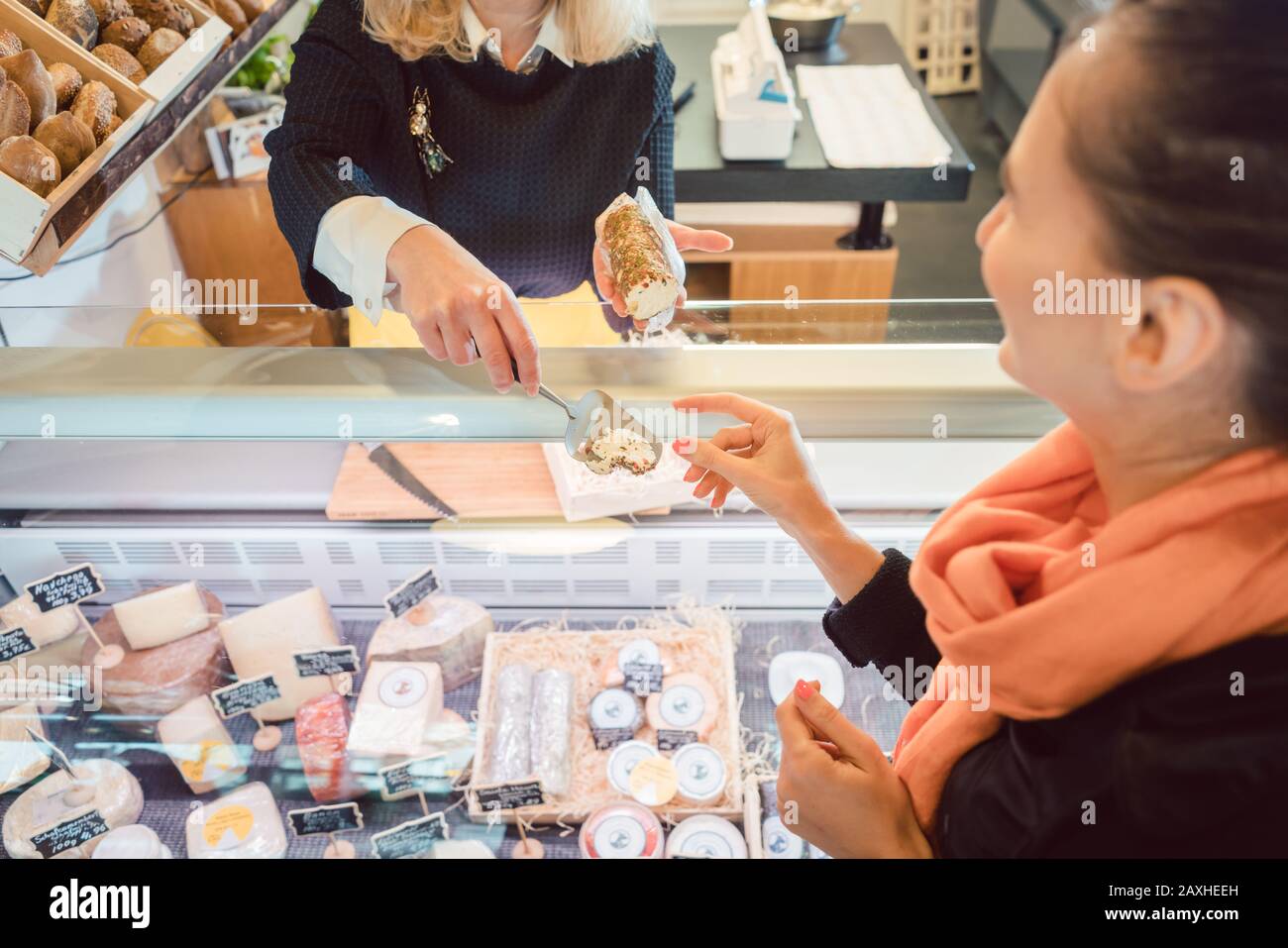 Cliente e commesso al banco del formaggio del supermercato Foto Stock