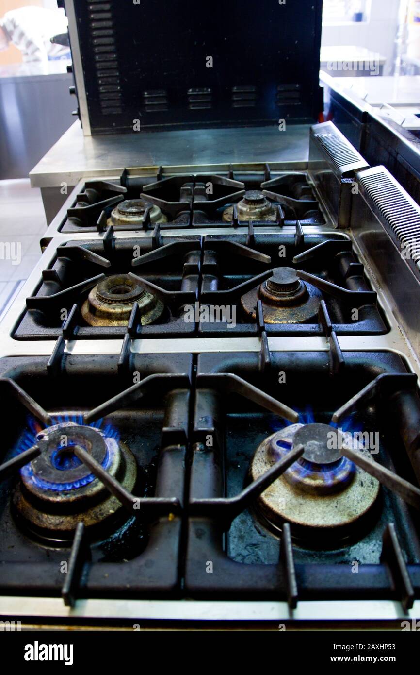 High angolo colpo di fiamme blu in una stufa con uno sfondo sfocato Foto Stock