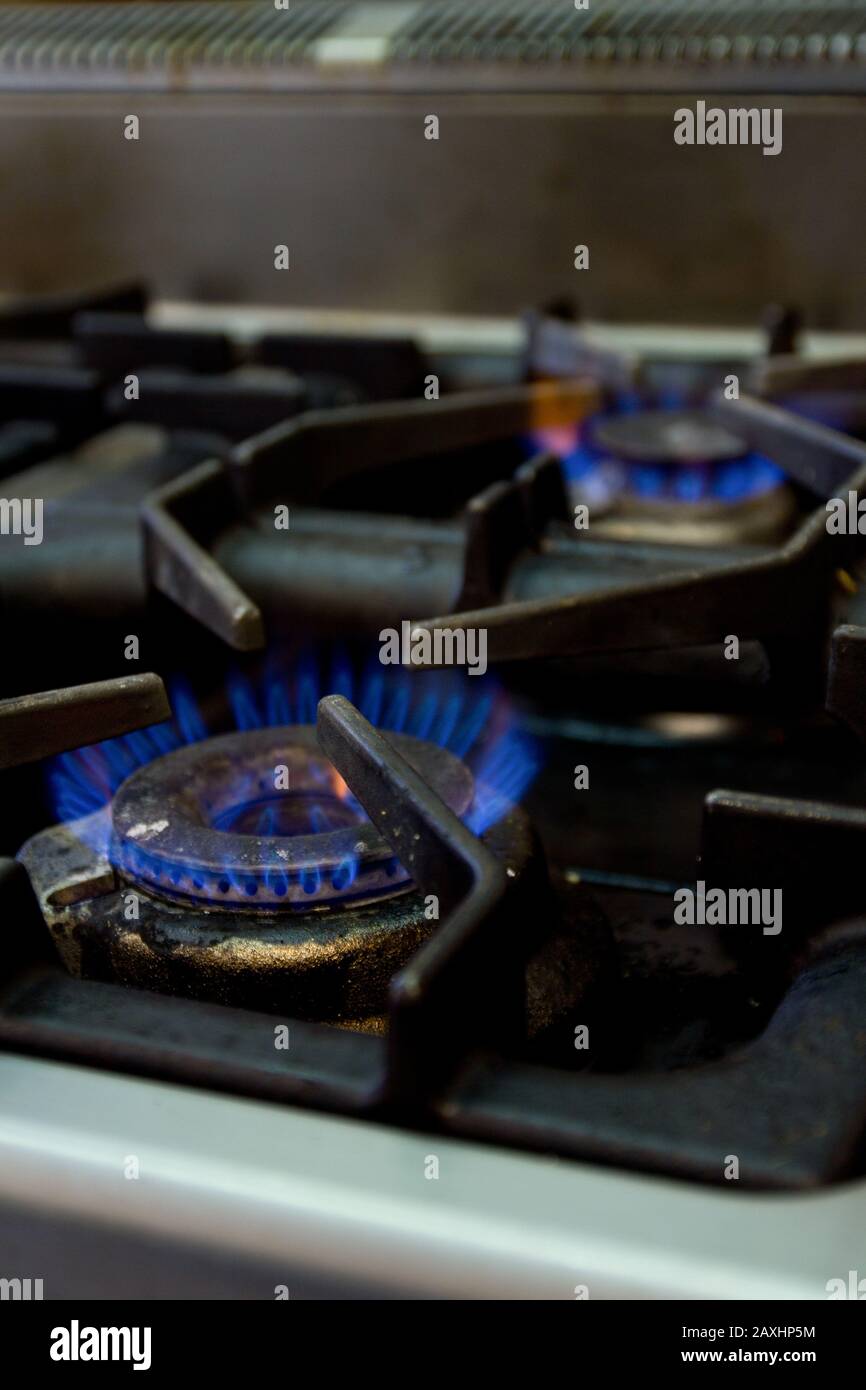 Fuoco selettivo colpo di fiamme blu in una stufa con uno sfondo sfocato Foto Stock