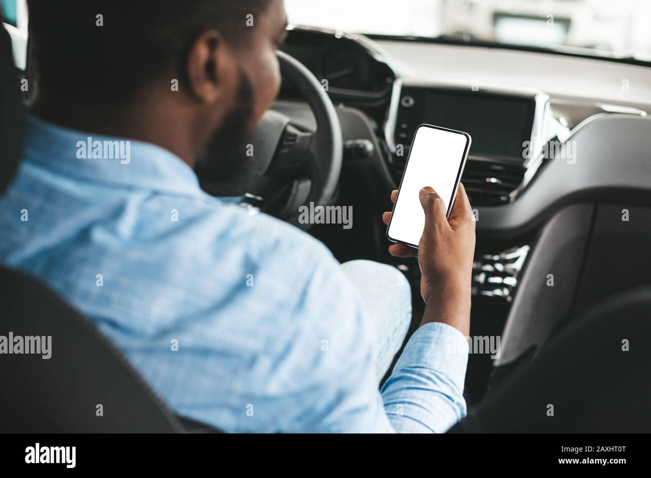 Uomo Che Utilizza Il Telefono Con Lo Schermo Vuoto Seduto In Auto, Vista Posteriore Foto Stock