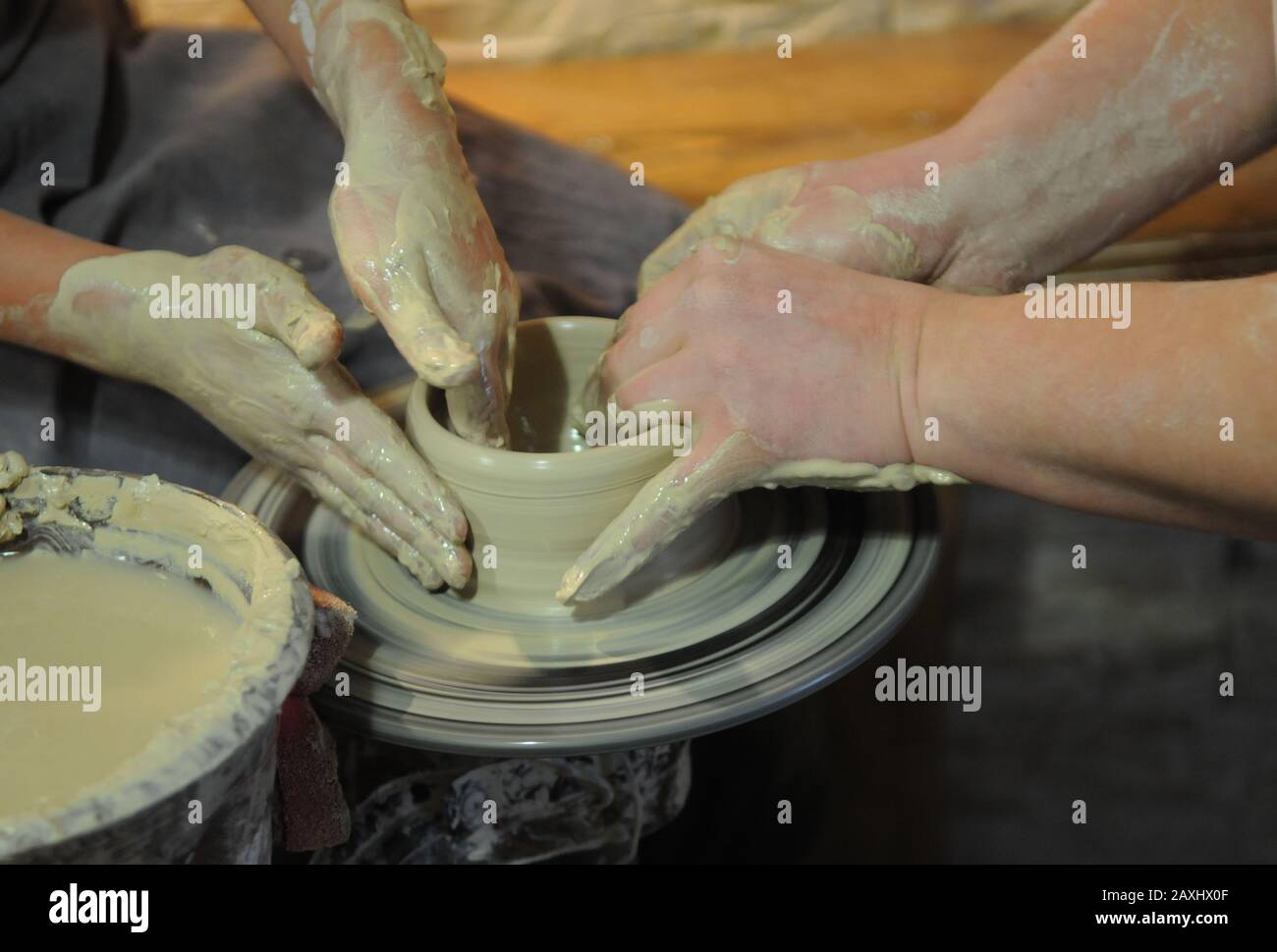 Lezione di ceramica, solo le mani sono visibili. Tutto è in argilla. Foto Stock