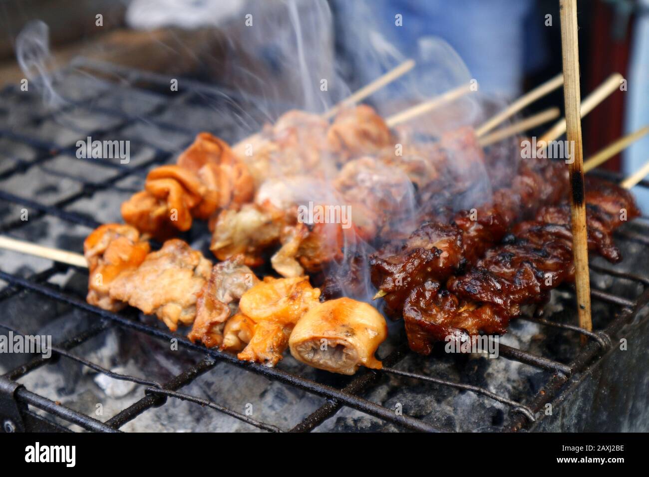 Foto dell'intestino di maiale alla griglia in bastoncini da barbecue venduti in una stalla di cibo di strada. Foto Stock