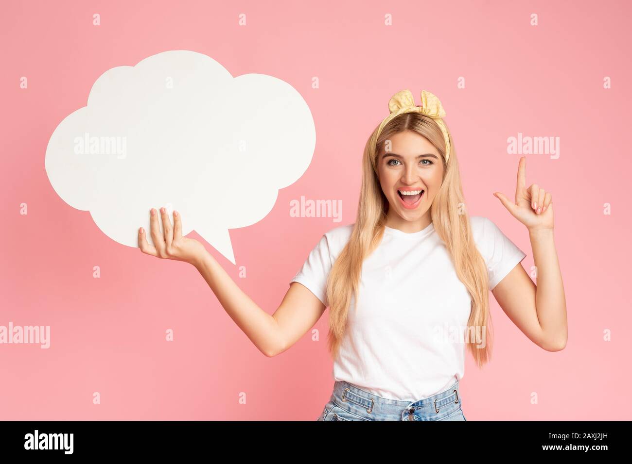 Ritratto della ragazza che tiene la bolla del discorso allo studio rosa Foto Stock