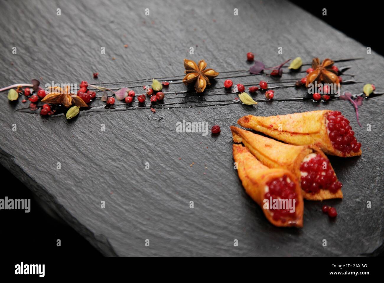 Pate di coniglio in corni croccanti decorato con spezie su un piatto di pietra nera Foto Stock