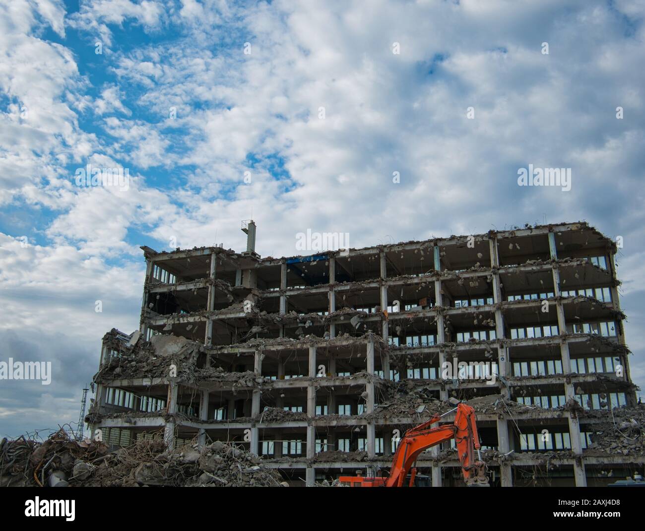 Un edificio completamente eviscerato per uffici viene demolito con l'escavatore Foto Stock