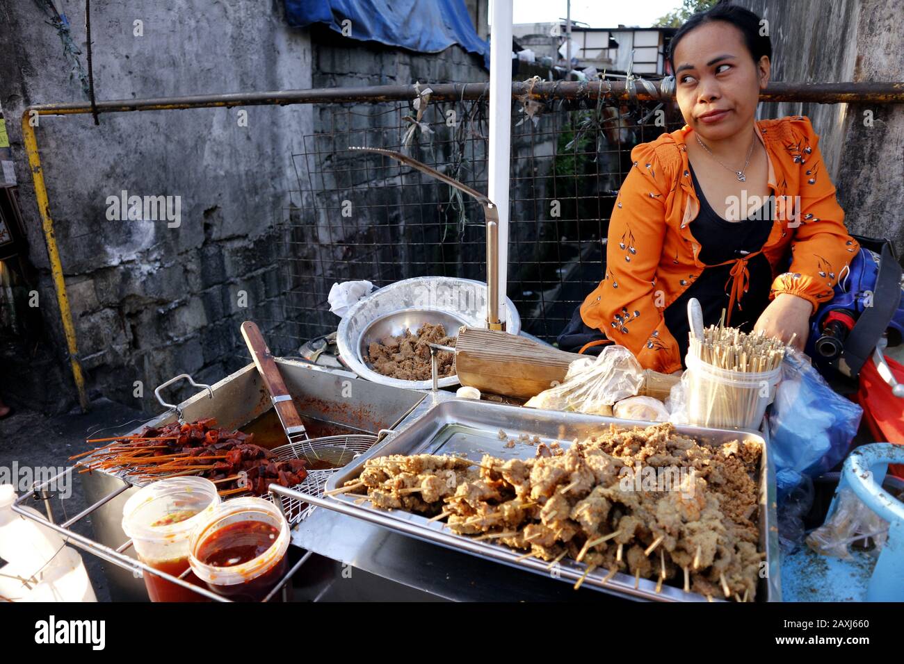 Antipolo City, Filippine - 11 febbraio 2020: Street food Vendor vende interiora di maiale alla griglia e fritta in uno stallo improvvisato lungo un marciapiede Foto Stock