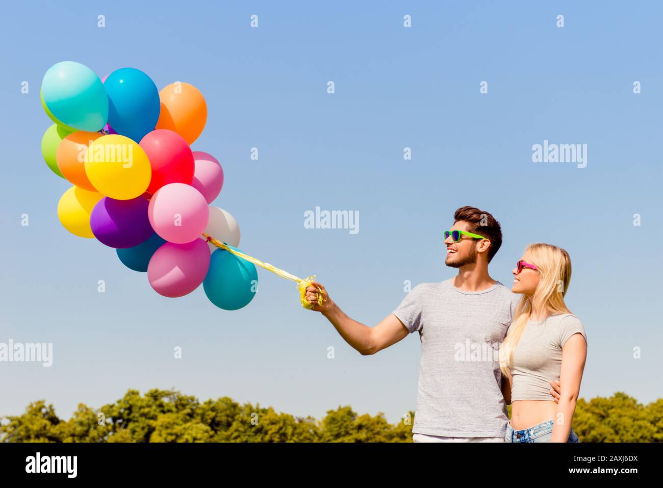 Ritratto di uomo e donna in amore tenendo palloncini colorati Foto Stock