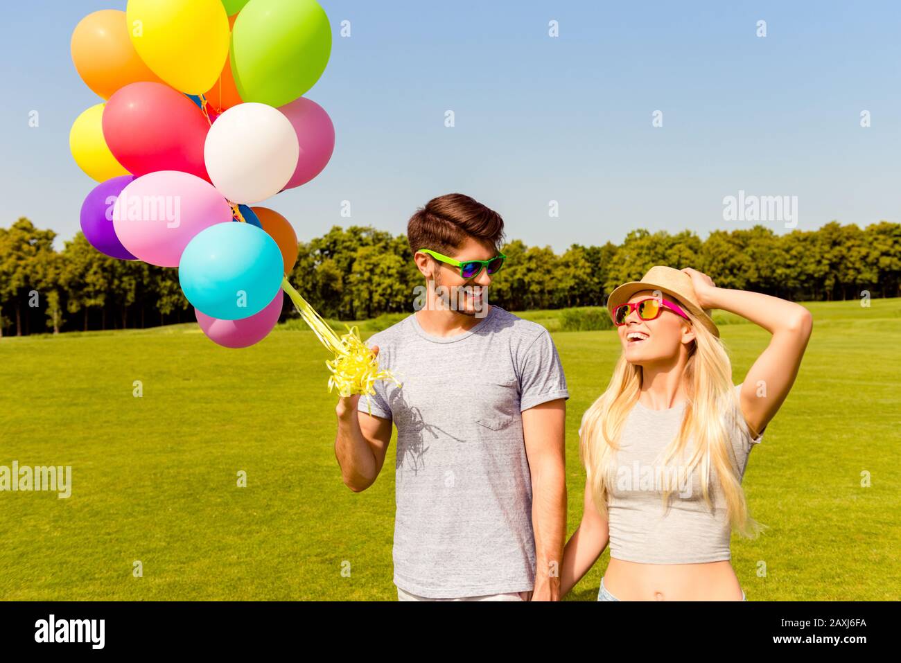 Felice giovane coppia innamorata di palloncini colorati nel parco Foto Stock