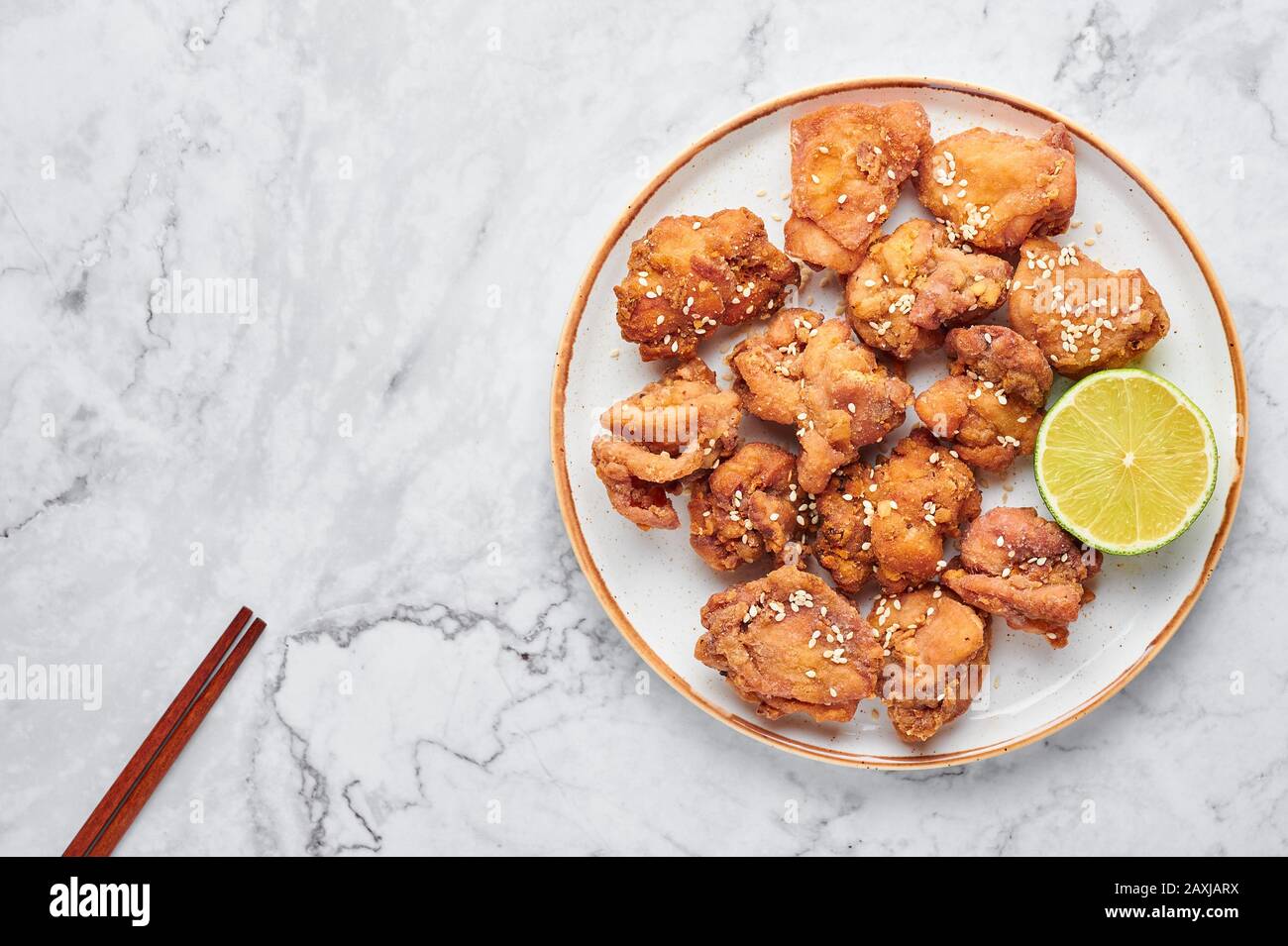 Karaage di pollo in piatto bianco su sfondo di marmo bianco. Karaage è un piatto tradizionale giapponese con pollo marinato fritto. Spazio di copia, Foto Stock