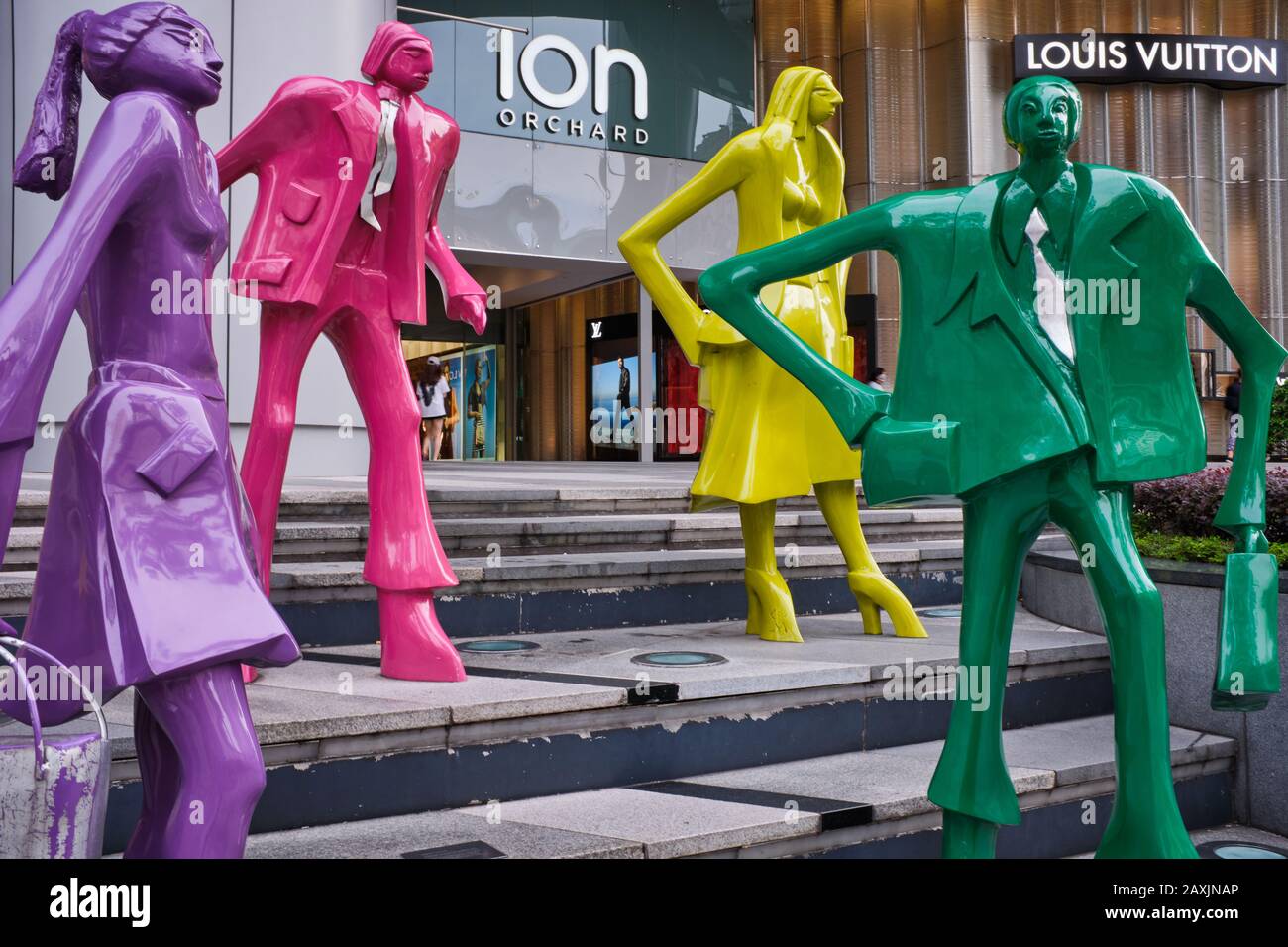 Figure colorate e astratte di acquirenti fuori ION Orchard (centro commerciale), in Orchard Road, Singapore, con negozi di alta moda Prada e Louis Vuitton nel b/g. Foto Stock