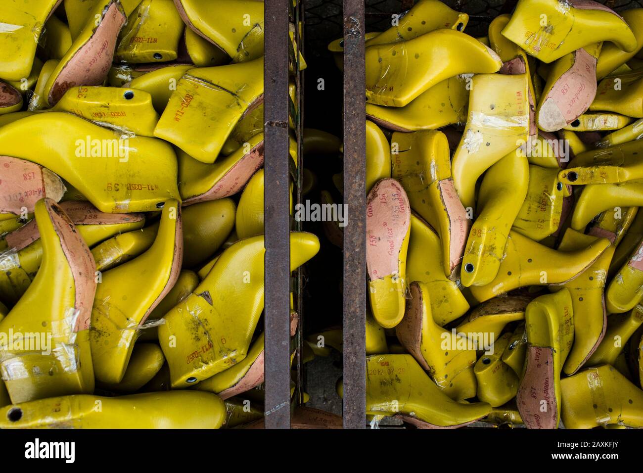 Angolo di chiusura elevato di contenitori di stampi per scarpe gialli in una fabbrica. Foto Stock