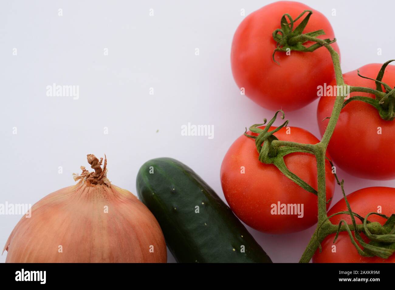 Pomodori un cetriolo e cipolla su uno sfondo completamente bianco Foto Stock