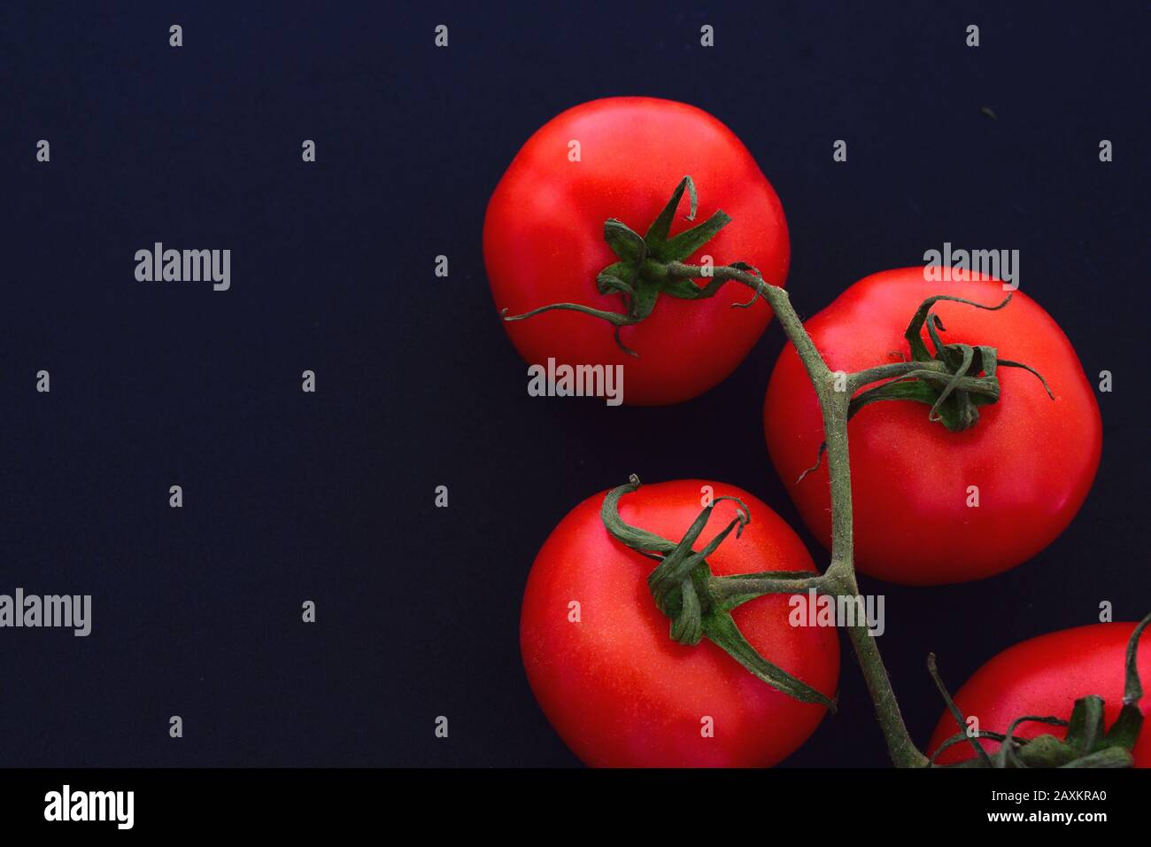 Mazzo di pomodori con sfondo scuro Foto Stock