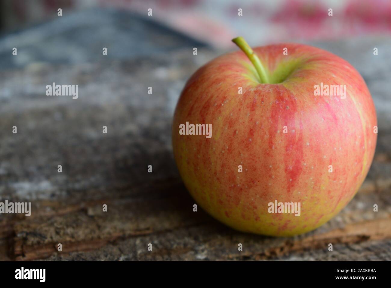Vista ravvicinata di una mela sulla parte superiore di un vecchio tavolo in legno Foto Stock