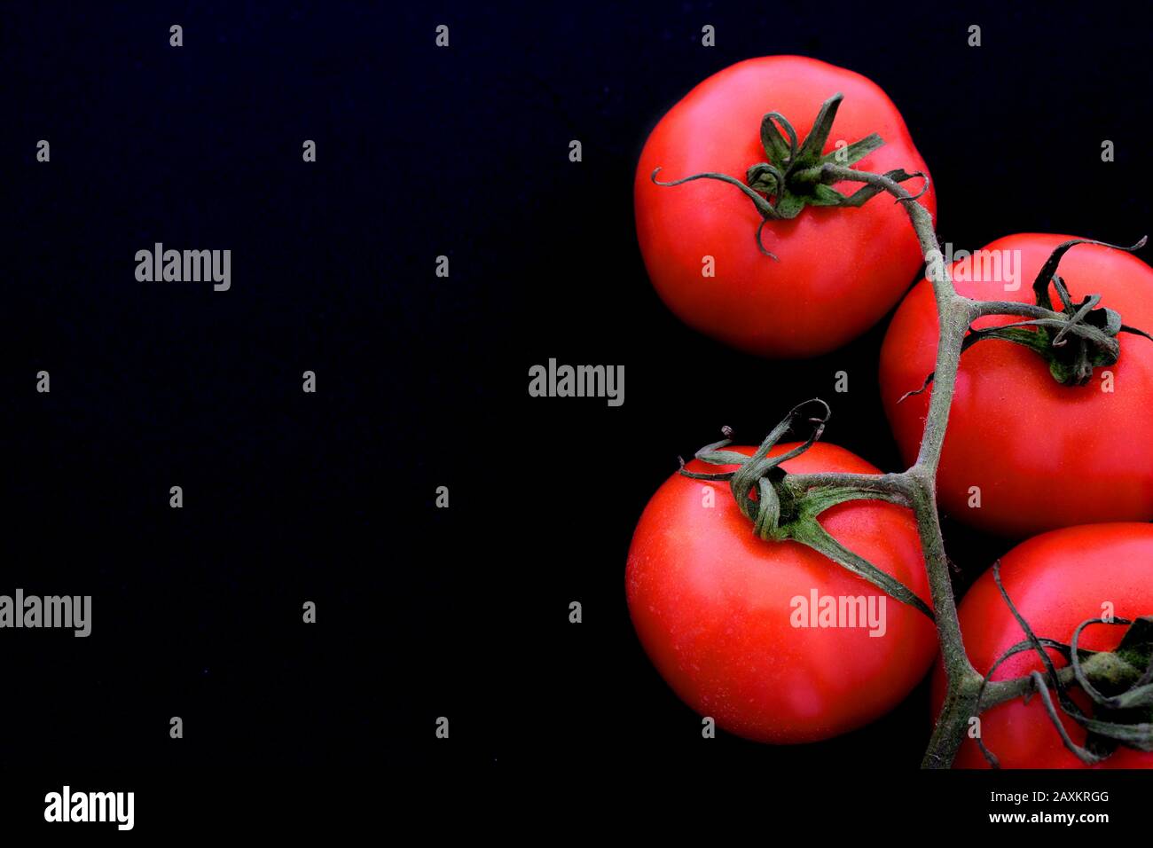 Mazzo di pomodori con sfondo nero Foto Stock
