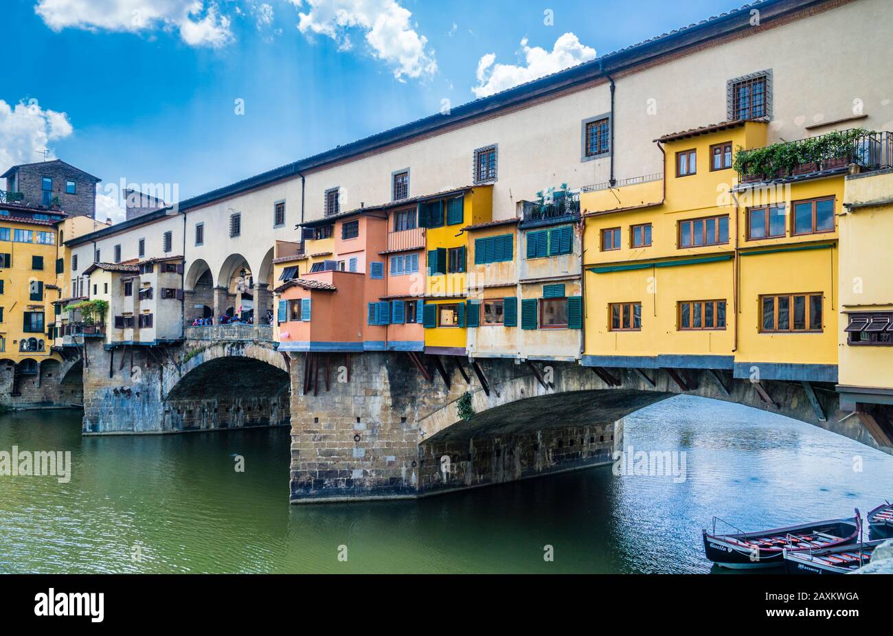 Il ponte dell'arco medievale in pietra di Ponte Vecchio, che attraversa l'Arno a Firenze, è fiancheggiato dai negozi di gioiellerie, commercianti d'arte e venditori di souvenir, Foto Stock