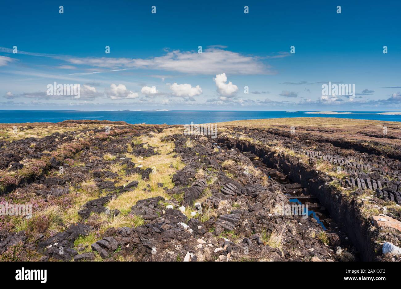 Torba da taglio per l'estrazione di torba (torba) per il tradizionale combustibile domestico a Bloody Foreland, County Donegal, con Tory Island sullo sfondo. Foto Stock