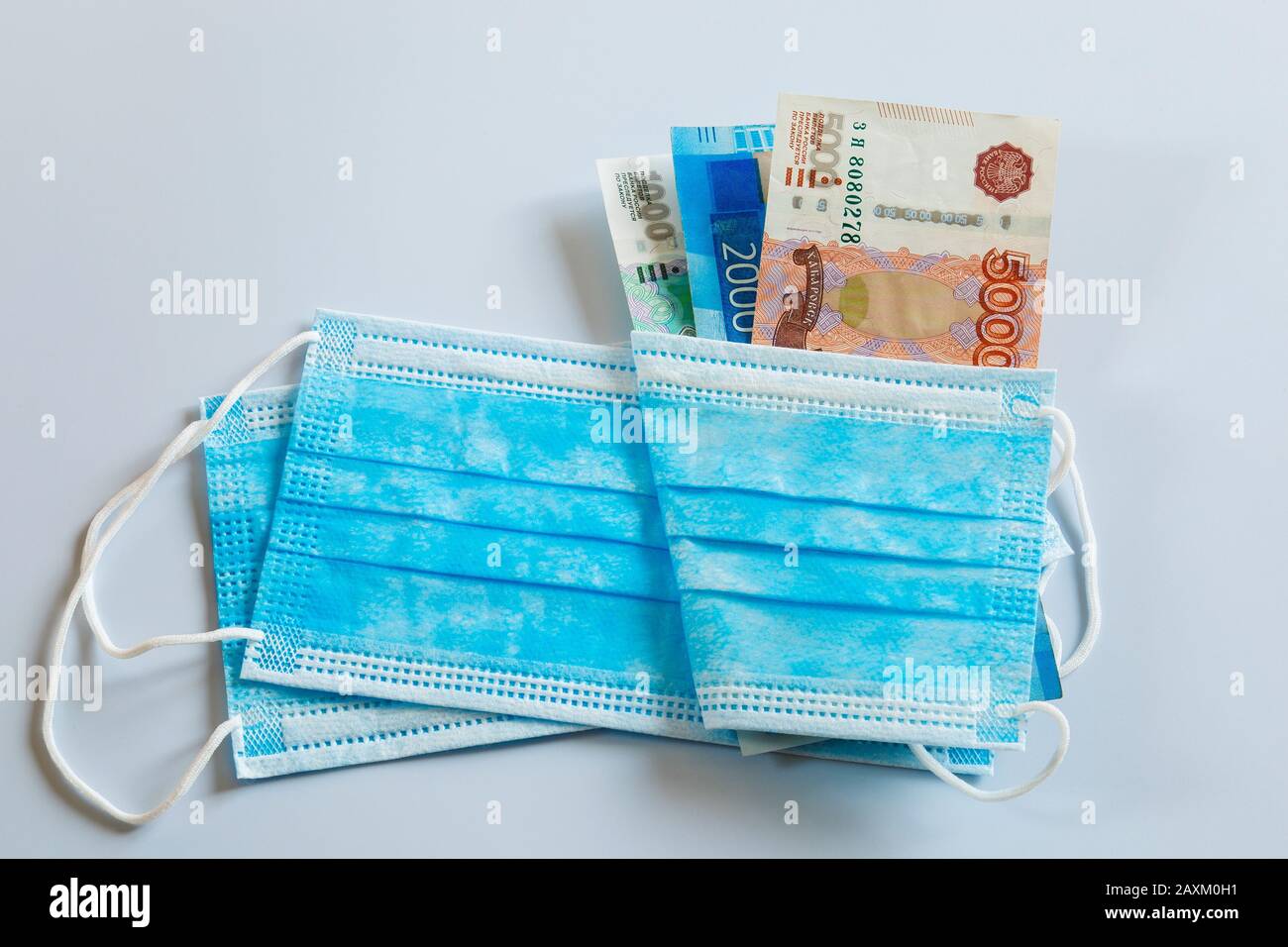Maschere mediche e banconote in valuta russa come simbolo di prezzi più alti per la protezione respiratoria dai virus. Foto Stock